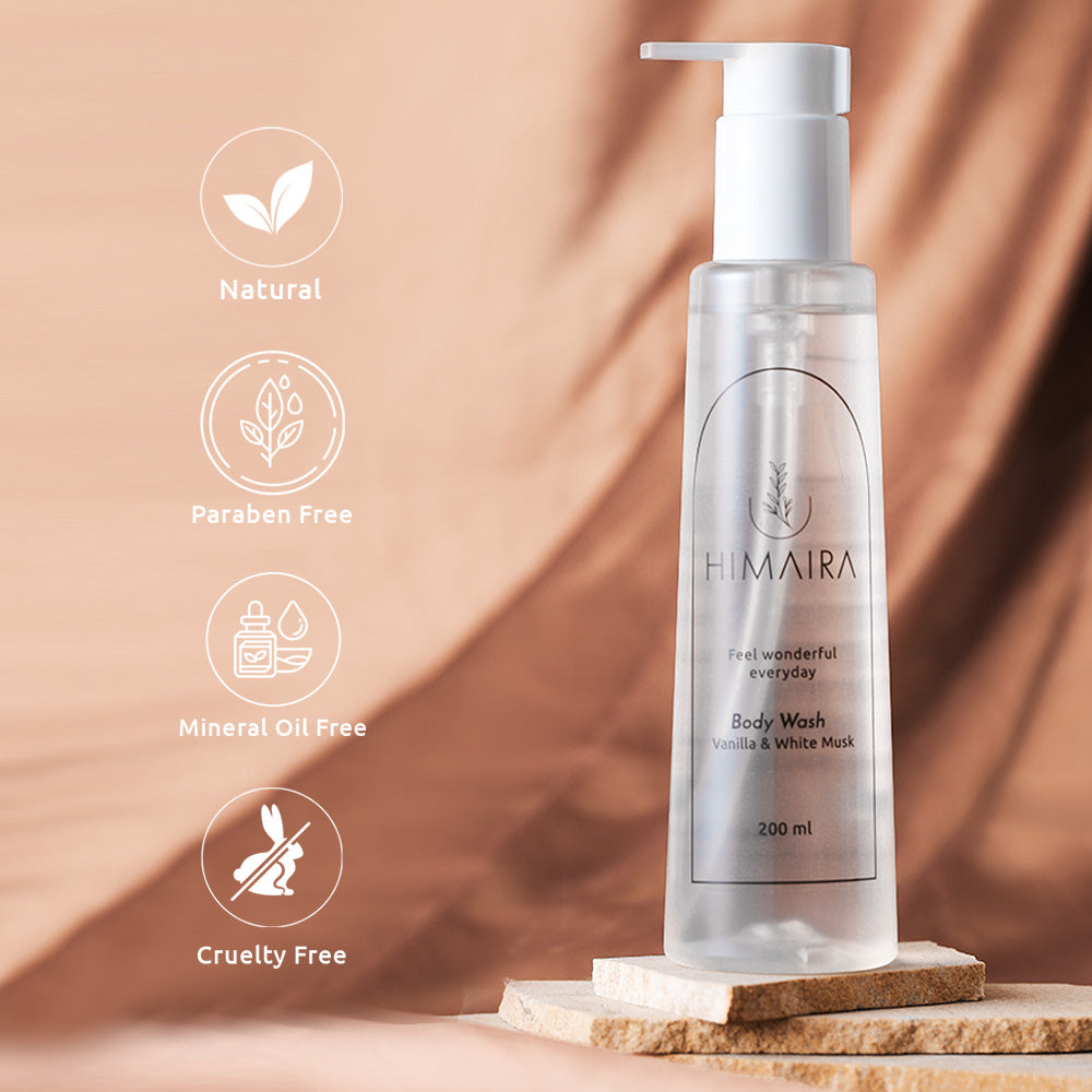 A clean product shot of Vanilla & White Musk Body Wash on marble with natural backdrop with icons like natural leaves, paraben free, cruelty free and mineral free oil.